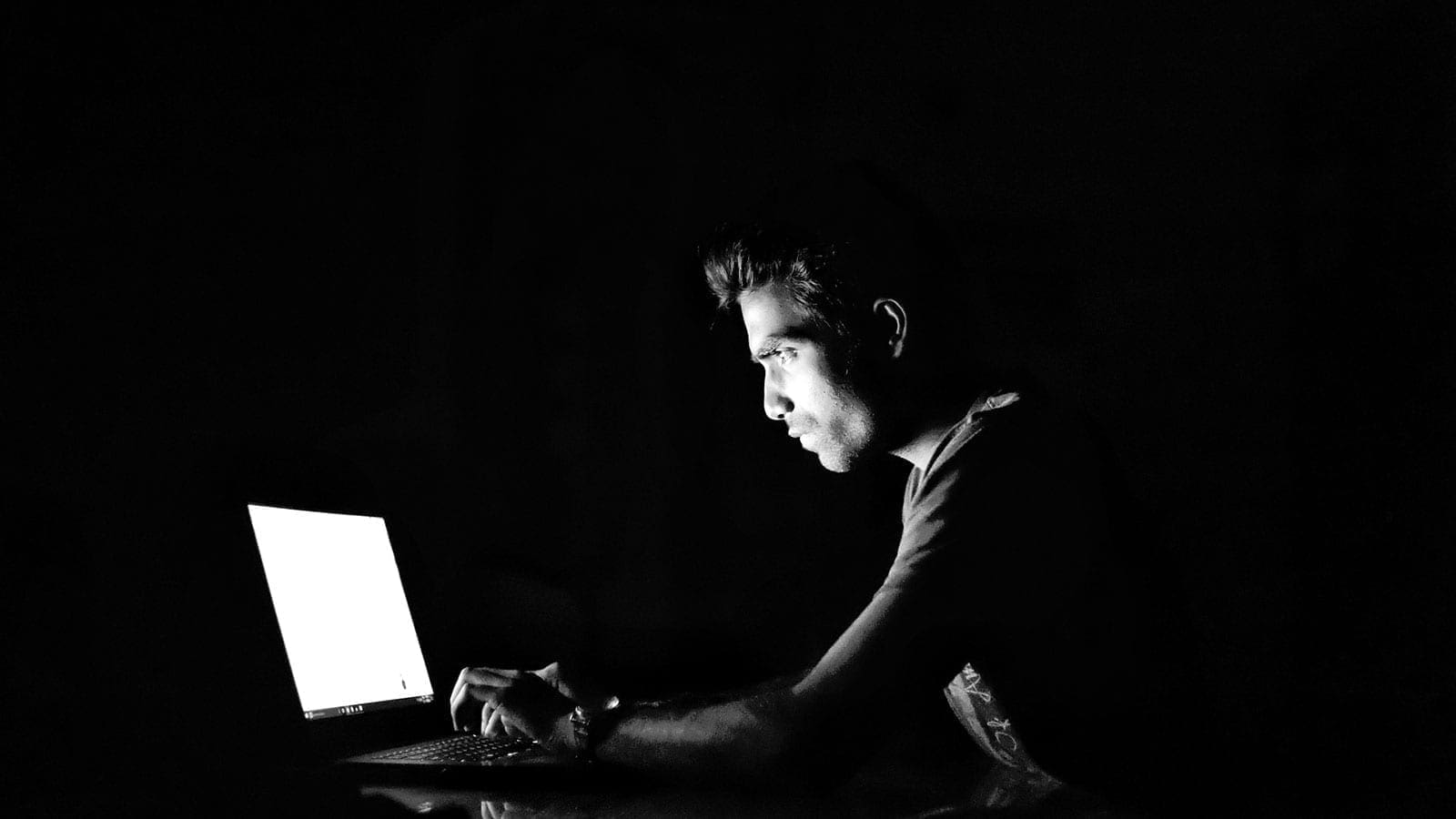 person using laptop in the dark